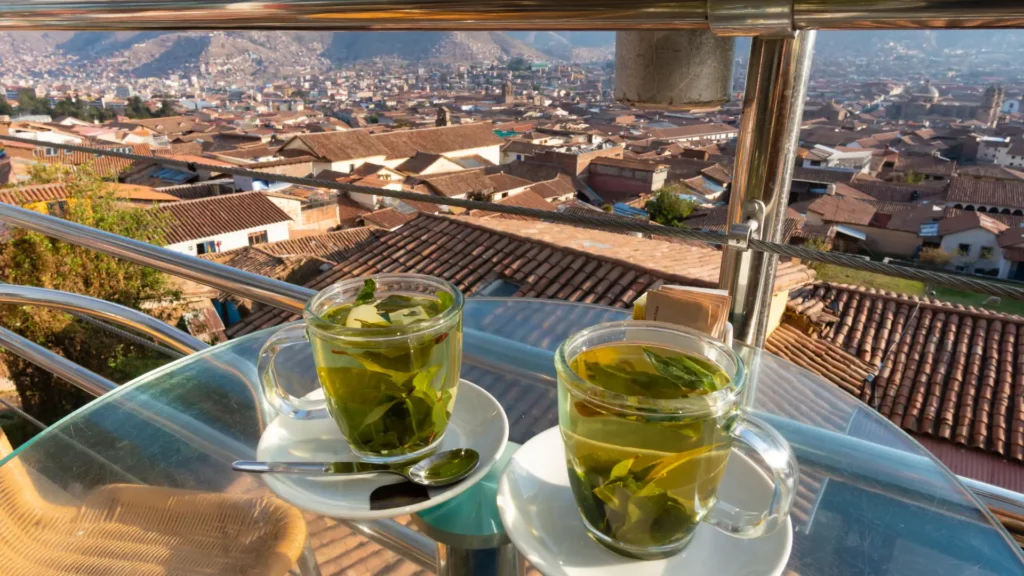 A traveler practicing Cusco acclimatization techniques with traditional tea